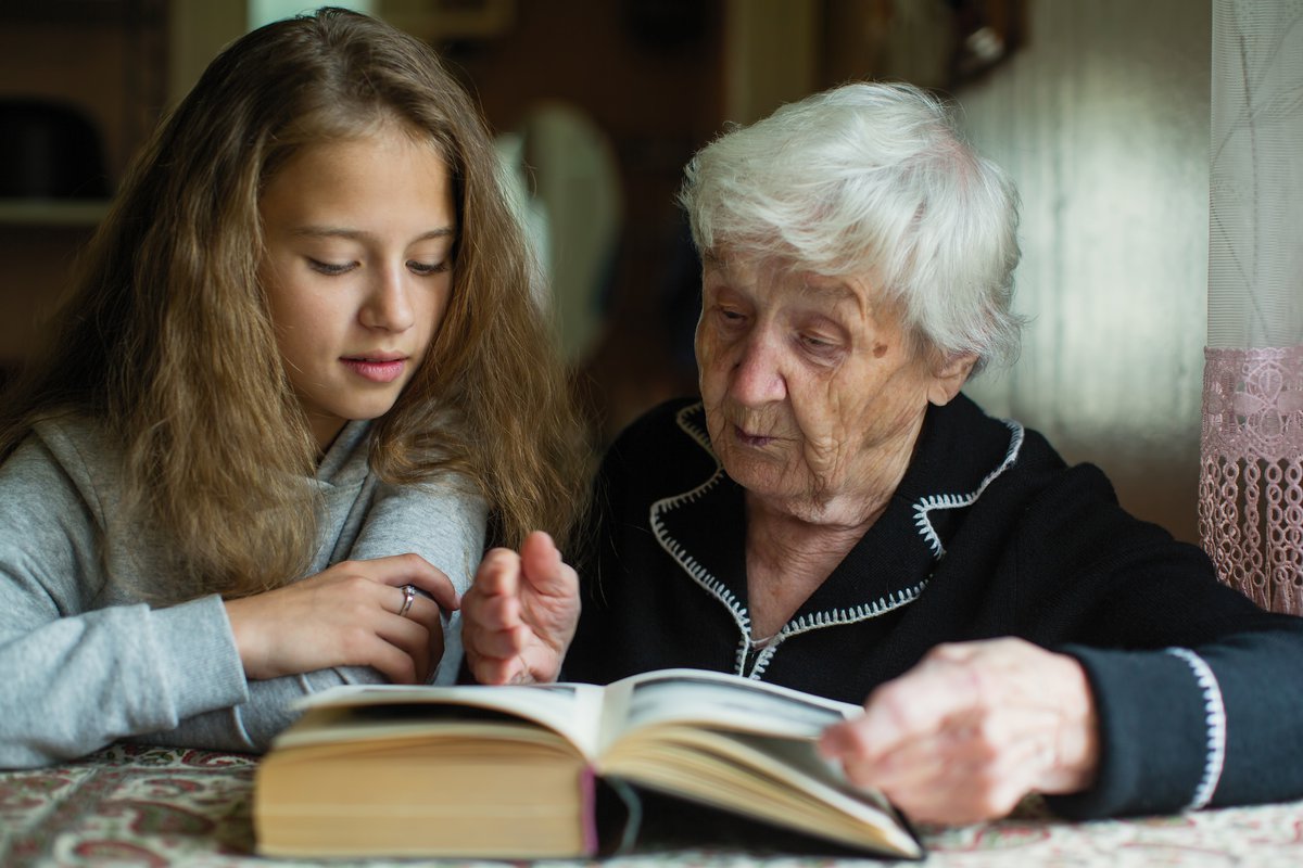 Babcia z wnuczką czytające książkę.